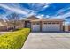 Two-story home with attached three-car garage, desert landscaping, and a green hedge at 5071 Andover Ct, Pahrump, NV 89061