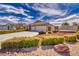 Two-story home featuring manicured landscaping, desert rock, and three-car garage at 5071 Andover Ct, Pahrump, NV 89061