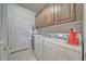 Utility room with laundry machines, sink, storage cabinets, and a door to the outside at 5071 Andover Ct, Pahrump, NV 89061
