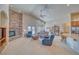 Bright living room featuring a stone fireplace, ceiling fan, and comfortable seating area at 5071 Andover Ct, Pahrump, NV 89061