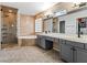 Elegant bathroom featuring a dual vanity, soaking tub, glass-enclosed shower, and travertine tile at 5505 Big Sky Ln, Las Vegas, NV 89149