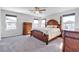 Spacious main bedroom featuring a four-poster bed, soft carpet, neutral walls, and natural light from the windows at 5820 Delaney Falls St, North Las Vegas, NV 89081