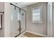 Contemporary bathroom features a glass-enclosed shower, white tile, and shuttered window, creating a spa-like experience at 690 Monroe Hill Pl, Henderson, NV 89011