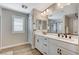 Bright bathroom with a double vanity, modern fixtures, and wood-look tile flooring, providing a luxurious feel at 690 Monroe Hill Pl, Henderson, NV 89011