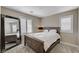 Comfortable bedroom with a wood-framed bed, ample natural light from shuttered windows, and a full length mirror at 690 Monroe Hill Pl, Henderson, NV 89011