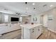 Open kitchen area with white cabinets, a large island with seating, and modern pendant lighting at 690 Monroe Hill Pl, Henderson, NV 89011