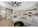 Bright living area that flows into the kitchen, features wood-look floors, and modern lighting at 690 Monroe Hill Pl, Henderson, NV 89011