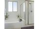 Bright bathroom showcasing a tub and tiled shower, complemented by natural light from a window at 7722 Sagamore Bay Ct, Las Vegas, NV 89179