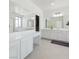 Bright bathroom showing double sinks, a large mirror, vanity and a walk-in closet for ample storage at 7722 Sagamore Bay Ct, Las Vegas, NV 89179