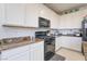 Bright kitchen with granite countertops, white cabinets, and modern appliances at 7722 Sagamore Bay Ct, Las Vegas, NV 89179