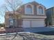 Charming two-story home featuring a large two car garage, classic windows, and desert landscaping at 8125 Rio De Janeiro Dr, Las Vegas, NV 89128