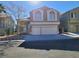 Charming two-story home featuring a large two car garage, classic windows, and desert landscaping at 8125 Rio De Janeiro Dr, Las Vegas, NV 89128