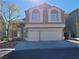 Charming two-story home featuring a large two car garage, classic windows, and desert landscaping at 8125 Rio De Janeiro Dr, Las Vegas, NV 89128