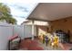 Cozy covered patio with brick flooring and a white fence for added privacy at 9293 Boltonia Ct, Las Vegas, NV 89149