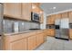 Well-lit kitchen with stainless steel appliances, light wood cabinets, and granite countertops at 933 Monte Nerone Ave, Henderson, NV 89012
