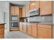 Updated kitchen with stainless steel double oven, gas cooktop, granite countertops, and wooden cabinetry at 933 Monte Nerone Ave, Henderson, NV 89012