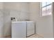Convenient laundry room with washer, dryer, window, and shelving for storage at 933 Monte Nerone Ave, Henderson, NV 89012