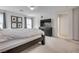 Spacious bedroom with neutral walls, carpet, a large bed and black dresser under a flat screen TV at 933 Monte Nerone Ave, Henderson, NV 89012