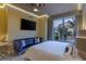 Bedroom featuring a flat screen TV, blue sofa, and bright window view at 1 Hughes Center Dr # 308, Las Vegas, NV 89169