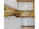 Bright laundry room featuring white washer and dryer, with a utility sink and storage cabinets at 1 Hughes Center Dr # 308, Las Vegas, NV 89169