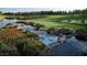 Scenic view of the golf course with a river, lush greenery and sand traps on a bright sunny day at 11036 Parete Ct, Las Vegas, NV 89141