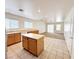 Open kitchen with wooden cabinets and a center island, flowing into a carpeted living space at 11036 Parete Ct, Las Vegas, NV 89141
