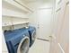 A laundry room with modern washer and dryer and white shelving at 11036 Parete Ct, Las Vegas, NV 89141