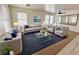 Cozy living room showcasing a gray sofa, glass coffee table, and plush blue rug at 11036 Parete Ct, Las Vegas, NV 89141