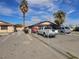 Modest single-story home with a spacious driveway and fenced yard, complemented by mature palm trees at 1608 Putnam Ave, North Las Vegas, NV 89030