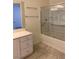 Bathroom with a glass-enclosed shower over tub, tiled floor, and vanity with storage at 1742 Franklin Chase Ter, Henderson, NV 89012