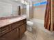 Well-lit bathroom featuring granite countertops, a bathtub with shower, tiled walls, and neutral decor at 2456 Palmridge Dr, Las Vegas, NV 89134
