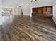 Spacious living room with wood-look flooring, a built-in wall unit, ceiling fans, and ample natural light from large windows at 2456 Palmridge Dr, Las Vegas, NV 89134