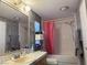 Bathroom featuring a shower-tub combo with pink curtain, toilet and sink with mirror at 2471 Mcmurray Dr, Pahrump, NV 89060
