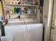 Washer and dryer sitting side by side with cleaning supplies on shelves above at 2471 Mcmurray Dr, Pahrump, NV 89060