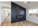 Bright, open living room with a modern fireplace with built-in tv and wood-look flooring at 2519 Sidney Spring St, North Las Vegas, NV 89030