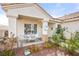Covered front porch with cozy seating, decorative accents, and lush plants for a welcoming entrance at 266 Corvallis Ct, Henderson, NV 89074