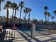 Community pool area surrounded by palm trees and secured by a black fence at 2692 Matogroso Ln, Las Vegas, NV 89121
