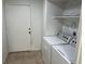 Laundry room featuring a white washer and dryer with tiled floor and extra storage space above units at 2692 Matogroso Ln, Las Vegas, NV 89121