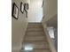 Staircase leading to the upper level with wood-look steps and white walls at 2692 Matogroso Ln, Las Vegas, NV 89121