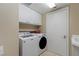 Bright laundry room with modern washer, dryer, sink, and overhead storage cabinets at 2747 Paradise Rd # 404, Las Vegas, NV 89109