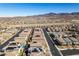 An aerial view shows desert homes with tile roofs in a planned community with mountains in the distance at 3192 Bormida Ave, Henderson, NV 89044