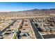 High-angle view showcasing a housing development with solar panels, surrounded by desert landscape and distant mountain silhouettes at 3192 Bormida Ave, Henderson, NV 89044