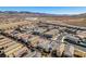 An aerial view shows desert homes with tile roofs in a planned community with desert landscape and mountains at 3192 Bormida Ave, Henderson, NV 89044