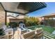 Backyard with modern patio cover, comfortable seating around a gas fire pit, and a manicured lawn at 3192 Bormida Ave, Henderson, NV 89044