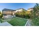 Backyard view with an outdoor seating area, fire pit, manicured lawn and landscaping at 3192 Bormida Ave, Henderson, NV 89044