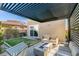 Backyard with a shaded patio area featuring a cozy seating arrangement and sleek, modern landscaping at 3192 Bormida Ave, Henderson, NV 89044