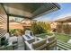 Backyard features a covered patio, fire pit, dog house, and lush landscaping at 3192 Bormida Ave, Henderson, NV 89044