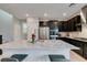 Elegant kitchen with stainless steel appliances, dark cabinets, and a marble countertop island with barstools at 3192 Bormida Ave, Henderson, NV 89044