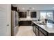 Open kitchen with a large island, dark cabinets, stainless appliances, and marble-like floors at 3192 Bormida Ave, Henderson, NV 89044