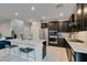 Modern kitchen features stainless appliances, dark cabinetry, and a marble countertop island with seating at 3192 Bormida Ave, Henderson, NV 89044